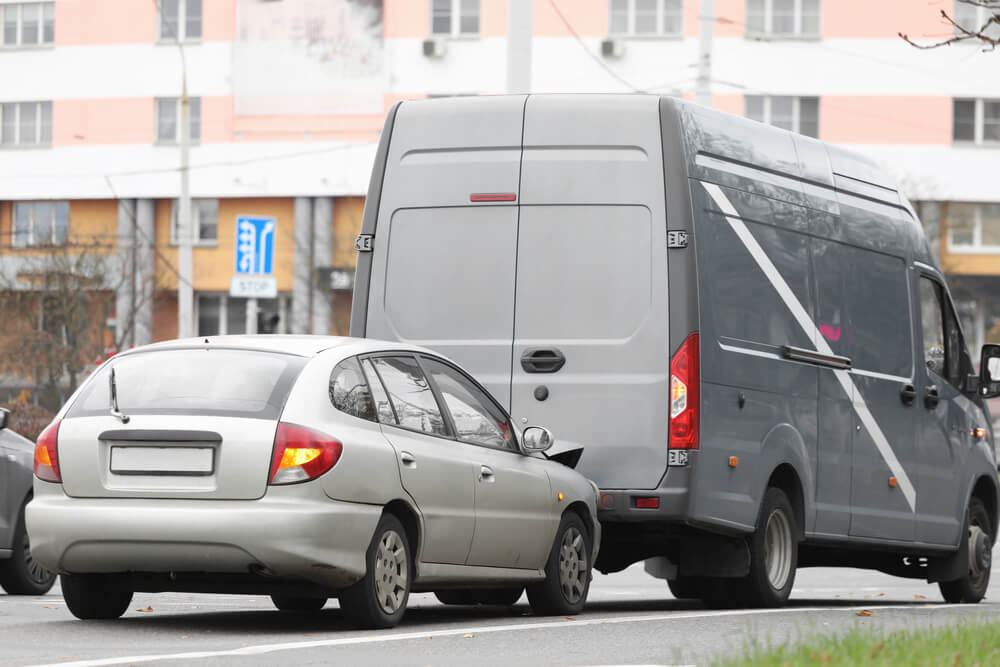 A photo of a car crashed into the back of a truck